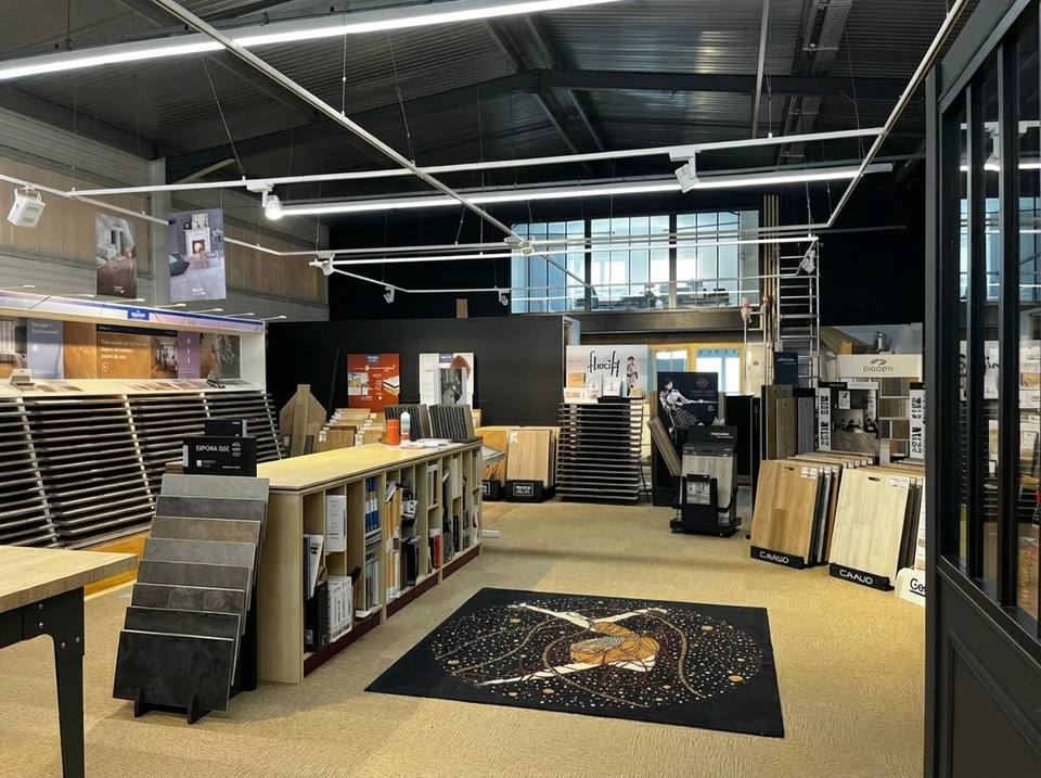Intérieur moderne avec grandes baies vitrées, stores enrouleurs dégradé orange installés, ampoules suspendues style industriel, plantes vertes en pots sur rebord de fenêtre